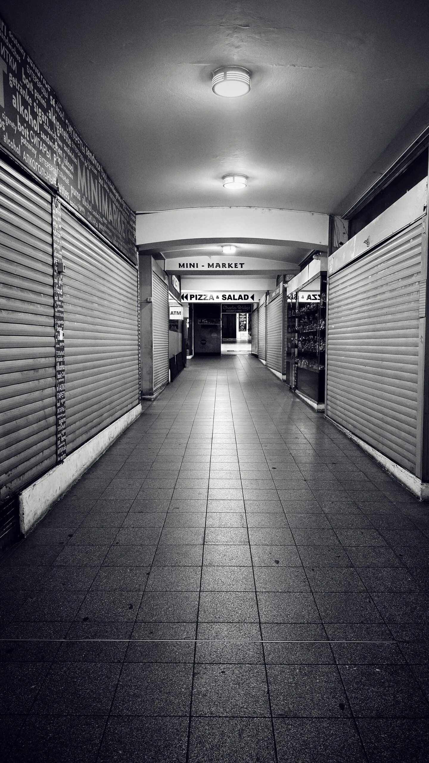 An empty shuttered market arcade in one-point perspective.