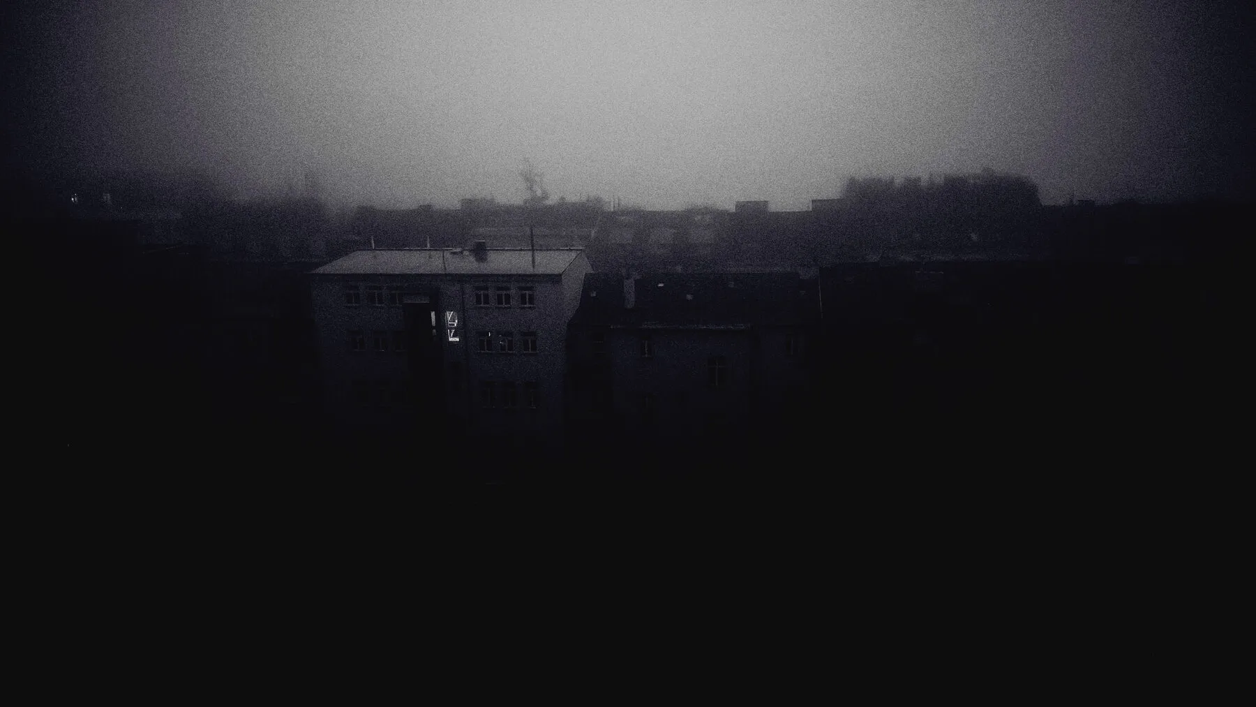 Prague rooftops dissolving into fog, printed almost black